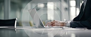 The professional hand typing on a sleek laptop in a modern office setting..AI generated image
