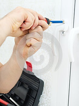 Professional handyman fixing window handle