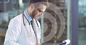 Professional healthcare doctor at work checking insurance paperwork for patient history inside a safe medical clinic