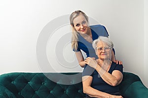 Professional and helpful caregiver comforting senior retired woman at nursing home. Happy retirement and healthcare