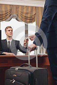 Professional hotel receptionist helping Businessman to check in and receive key from room