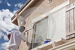 Professional House Painter Painting the Trim And Shutters of A H