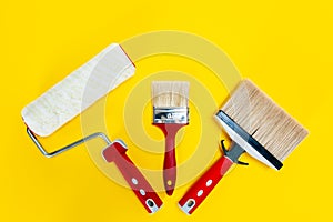 Professional house painter, work tools on yellow background