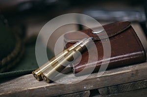 Professional hunters equipment for hunting. Detail on the ammunition. Wooden black background with rifle, hat, and other equipmen