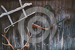 Professional hunters equipment for hunting. Rifle, Deer, Roe deer trophy sculs and others on a wooden black background. Trophy scu