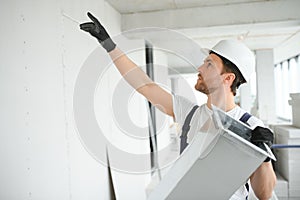 Professional HVAC Worker on a Aluminium Scaffolding Installing Air Duct Inside Newly Built Commercial Building