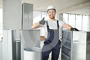 Professional HVAC Worker on a Aluminium Scaffolding Installing Air Duct Inside Newly Built Commercial Building