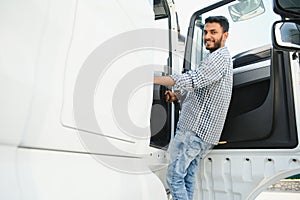 Professional indian truck driver entering his truck long vehicle. Loving his job. Transportation services.
