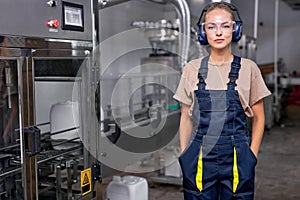 professional industrial woman engineer in spectacles standing in factory at work place