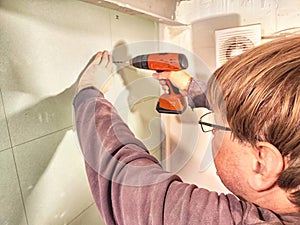 Professional Installs Drywall During Home Renovation. A skilled worker measures and secures drywall in home under