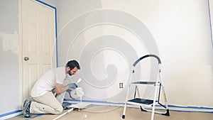 Professional interior construction worker pouring white color paint to tray
