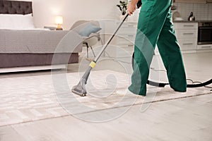 Professional janitor cleaning carpet in house