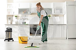 Professional janitor cleaning floor with mop
