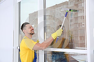 Professional janitor cleaning window with squeegee