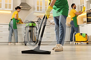 Professional janitors working in kitchen, closeup. Cleaning service