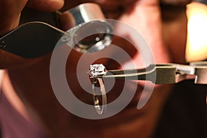 Professional jeweler evaluating beautiful ring, closeup