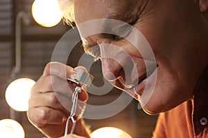 Professional jeweler evaluating ring in workshop, closeup