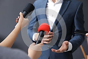Professional journalists interviewing businessman on background, closeup