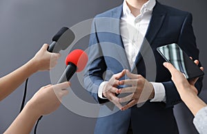Professional journalists interviewing businessman on background, closeup photo