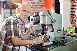 Professional key cutter making door keys copies in locksmith photo