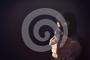 Professional killer on black background, focus on gun. Space for text