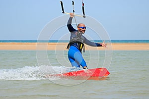 Professional kite boarding rider sportsman with kite rides blue lagoon smiling enjoying fun joy happy leisure rest relaxing time