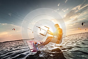 Professional kite surfer woman rides on a board with a plank in her hands on a leman lake with sea water at sunset