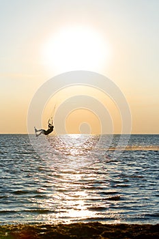 Professional kiter doing a complicated trick on a beautiful sunset background