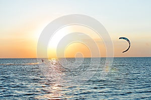 Professional kiter doing a complicated trick on a beautiful sunset background