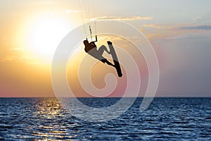 Professional kiter doing a complicated trick on a beautiful sunset background