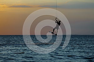 Professional kiter doing a complicated trick on a beautiful sunset background