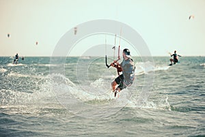 Professional kiter makes the difficult trick on a beautiful background