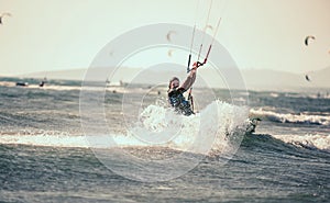 Professional kiter makes the difficult trick on a beautiful background