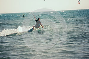 Professional kiter makes the difficult trick on a beautiful background