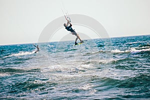 Professional kiter makes the difficult trick on a beautiful background