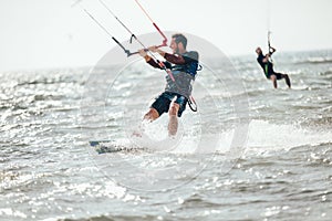 Professional kiter makes the difficult trick on a beautiful background. Kitesurfing