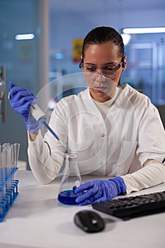 Professional laboratory worker using pipette for jar