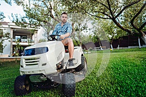 Professional landscaper using tractor at mowing lawn