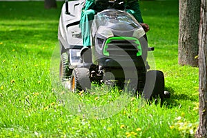 Professional lawn mower grass cutting in a park.