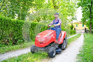 Professional lawn mower worker cutting grass in home garden