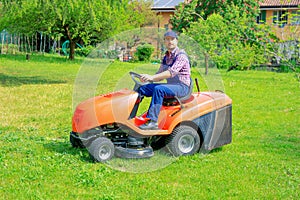 Professional lawn mower worker cutting grass in home garden