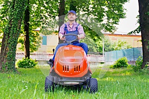 Professional lawn mower worker cutting grass in home garden