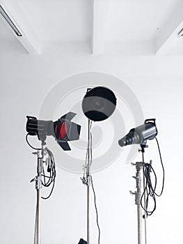 Professional lighting equipment, flashes, c-stands on a cyclorama in modern photo studio. Octabox, stripbox, softbox