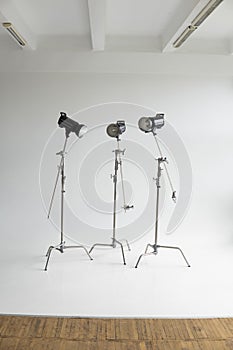 Professional lighting equipment, flashes, c-stands on a cyclorama in modern photo studio. Octabox, stripbox, softbox