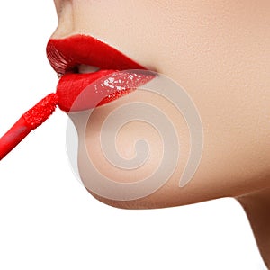 Professional lips make-up. Lipgloss and brush. Lipstick. Beauty girl applying lip gloss. lips. Beauty red lip makeup detail