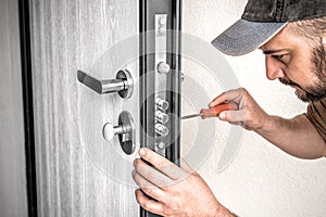 Locksmith repairing home entrance door lock