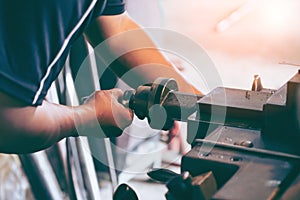 Professional machinist : man operating lathe grinding machine