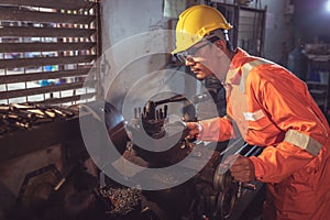 Professional machinist : Worker handles metal at lathe operating lathe grinding machine in uniform with safety - metalworking