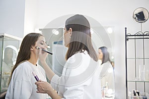 Professional make up artist doing make up in beauty salon