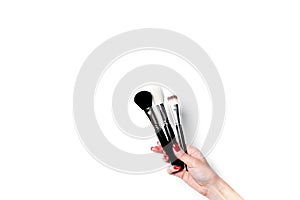 Professional make-up brush cosmetic in female hand beautician isolated on white background.